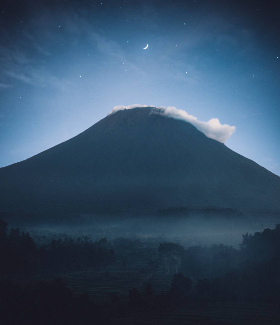 silhouette of mountain with mist on top